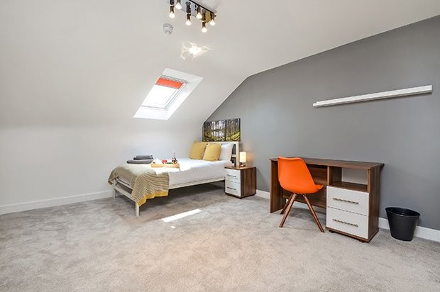 A bright double room in a shared house with a double bed, desk and chair